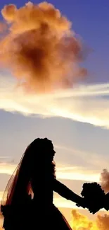 Silhouetted couple holding hands against a dramatic sunset sky.