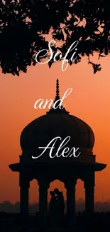 Romantic silhouette of a couple under a dome during an orange sunset.