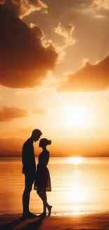 Couple silhouette against a beach sunset with orange skies.