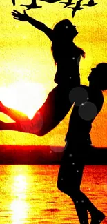 Silhouette of a couple embracing against a vibrant orange sunset backdrop.