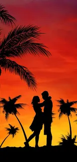 Silhouette of a couple under palm trees at a vibrant orange sunset.