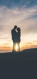 Silhouette of a couple embracing at sunset with a tranquil sky.