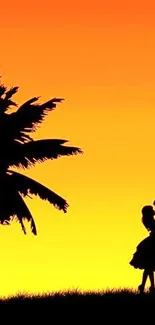 Romantic sunset silhouette of couple with palm tree.