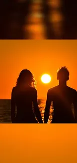 Silhouette of couple holding hands at sunset near ocean.