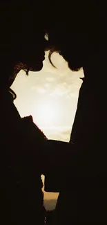 Silhouette of a couple in love at sunset with warm sky.