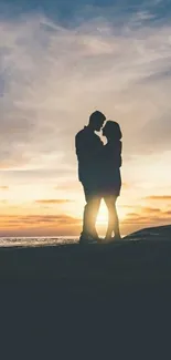 Silhouette of a couple embracing at sunset on the beach, with a romantic sky.