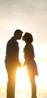 Silhouette of couple at sunset on beach.