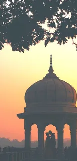 Monument silhouette at sunset with soft orange sky.