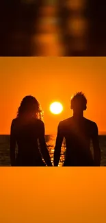 Silhouetted couple holding hands at ocean sunset.