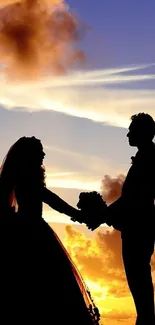 Silhouette of couple at sunset with orange sky.