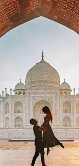 Romantic silhouette in front of Taj Mahal at sunrise.