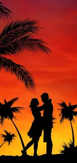 Silhouette of a couple at tropical sunset with palm trees.