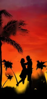 Silhouetted couple embracing under palm trees with a vivid orange sunset.