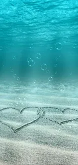 Entwined hearts on sandy ocean floor with ascending bubbles in turquoise water.