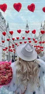 Woman with hat in city surrounded by red hearts.