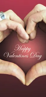 Hands forming a heart with Happy Valentine's Day text on pink background.