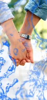 Couple holding hands with a blue watercolor effect overlay.