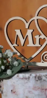 Heart-shaped wedding cake topper with flowers.