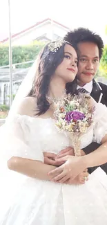 Bride and groom in a romantic embrace with a beautiful bouquet.