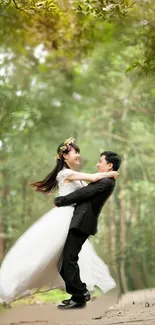 A couple in wedding attire embraces in a romantic forest setting with lush greenery.