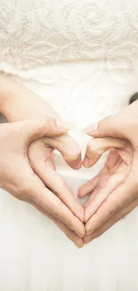 Hands forming a heart shape in a white lace dress, symbolizing love and unity.