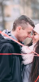 Couple embracing with heart balloons in winter.