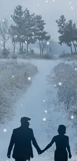 Couple walking on a snowy path through a tranquil winter landscape.