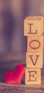 LOVE blocks with a red heart on a wooden background.