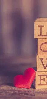 Wooden blocks spelling love with red heart accent.