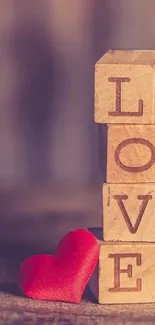 Wooden blocks spelling LOVE with red heart on warm brown background.