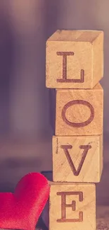 Stacked wooden blocks spelling 'LOVE' with red heart on a brown background.