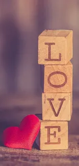 Wooden blocks spelling LOVE with red heart.