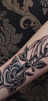 Rose and dagger tattoo art on forearm.