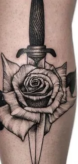 Black and white rose and dagger tattoo on skin background.