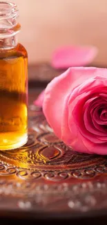 Pink rose and essential oil on an ornate plate.