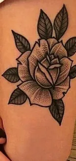 Arm with a detailed rose tattoo and shaded leaves.