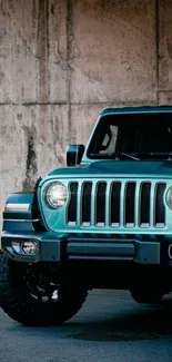 Blue Jeep SUV against a concrete wall in urban setting.