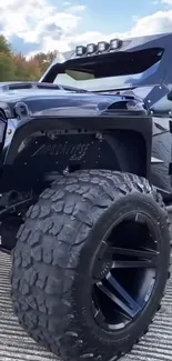 Rugged off-road vehicle with oversized tires on a scenic background.