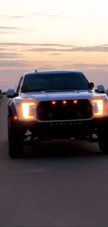 Rugged truck driving during sunset on a deserted road background.