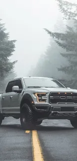 Truck driving through a foggy forest with mist and greenery.