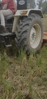 Tractor in a rural field, showcasing farming equipment and earthy scenery.