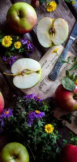 Rustic arrangement of apples and wildflowers on wooden surface.