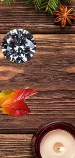 Rustic autumn wallpaper with brown wooden background, a diamond, leaves, and a candle.