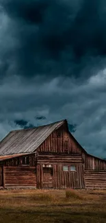 Rustic wooden barn under dark, stormy skies, creating a dramatic scene.