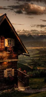 Rustic cabin with mountains under a warm sunset sky.