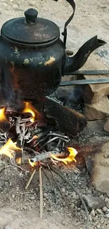 Campfire heating a rustic kettle with vibrant flames outdoors.