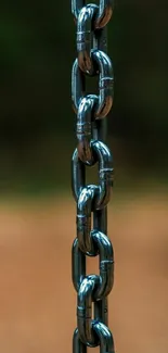 Close-up of a rustic chain against a blurred background for mobile wallpaper.