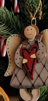 Rustic wooden Christmas angel with red heart on tree.