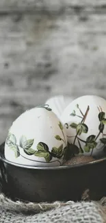 Rustic eggs with vine designs in a metal bowl.