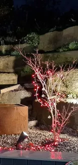 Rustic garden water feature with stones and lighting, creating a serene nighttime ambiance.